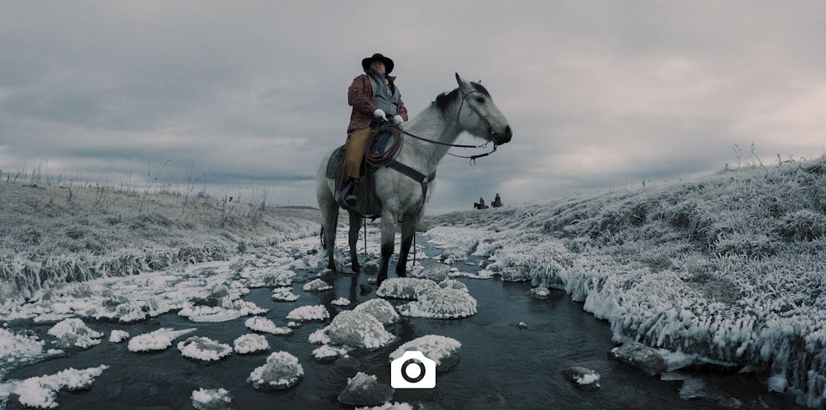 sample image of a cowboy on a white horse in a snowy river