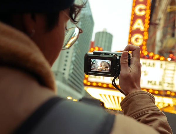 someone taking a photo of a chicago theatre using the gopro mission 1 in the point-and-shoot grip