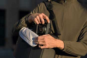 Photographer pulling Hasselblad X2D II 100C out of Vandra Camera Backpack side opening