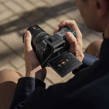 Photographer shooting with Hasselblad X2D II 100C at waist level with screen flipped out