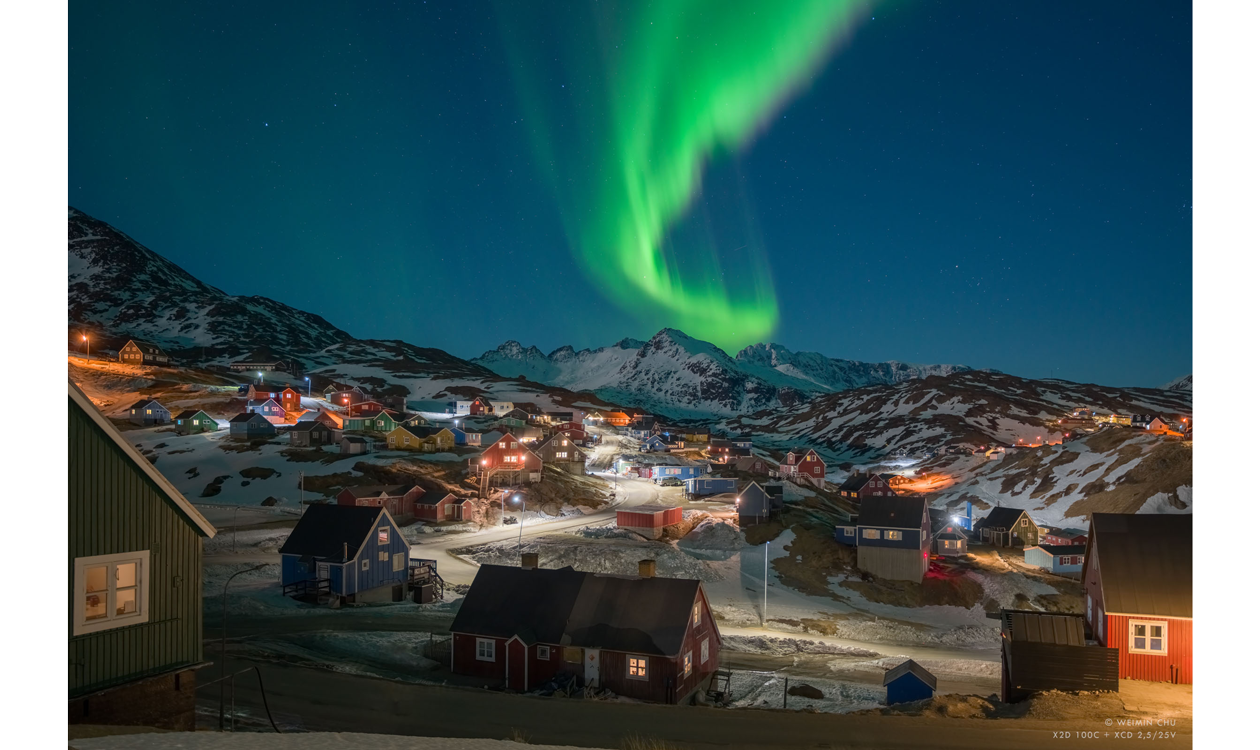 Landscape photograph of Greenland Village at night with Northern lights in the clear night sky