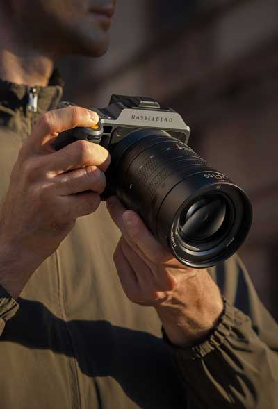 Photographer holding Hasselblad X2D II 100C with XCD 35-100mm lens