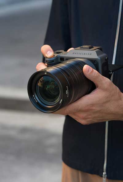 Photographer holding Hasselblad X2D II 100C with XCD 35-100mm lens
