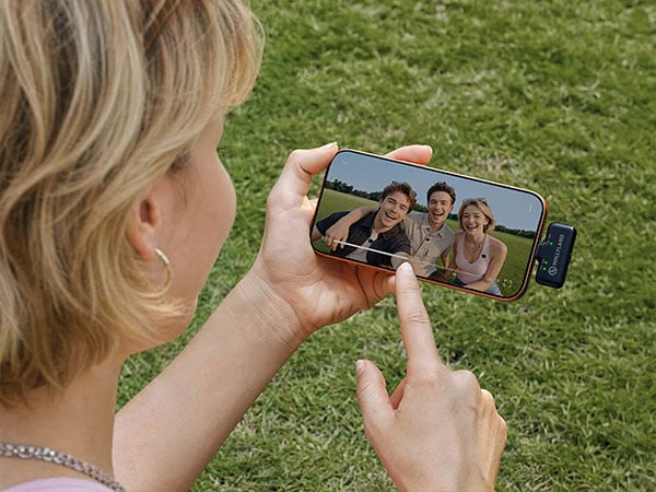 Woman outdoor viewing a family videos on her mobile phone