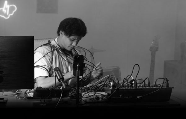 black and white image of someone struggling with cables in a sound studio