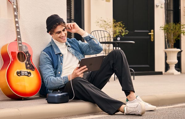 content creator sat on a curbside using an ipad connected to the melo p1