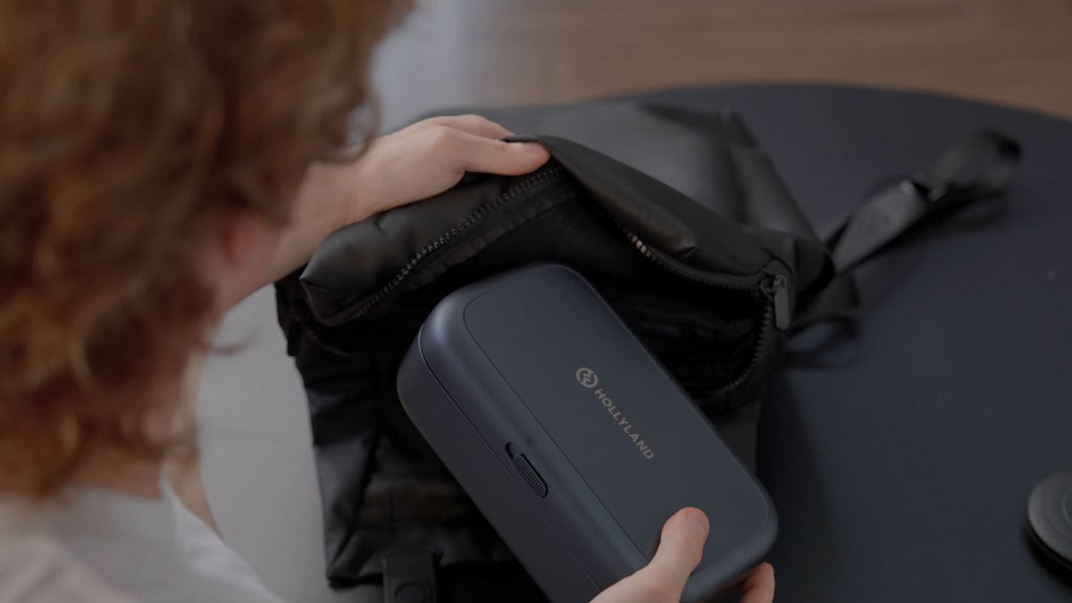 someone packing the melo p1 into a backpack