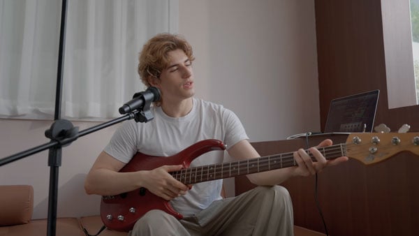 a musican playing a guitar on a sofa using the melo p1