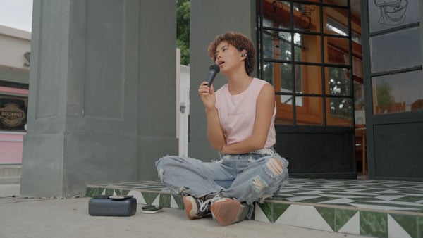 a woman filming outside a coffee shop using the melo p1