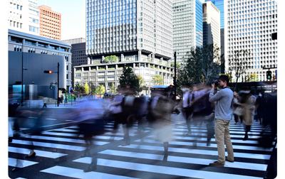 sample photograph long exposure of busy pedestrian crossing with people blurring in motion with photographer standing still in centre of road
