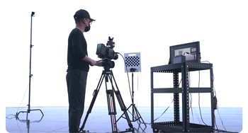 Camera operator calibrating camera with VIVE Mars CamTrack standing in Virtual production volume