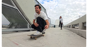 male skateboarder crouched riding along concrete walkway recording with insta360 ace pro and invisible selfie stick