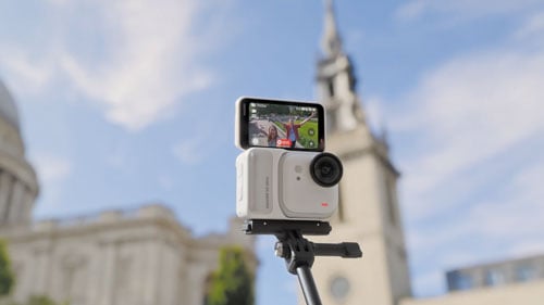 Insta360 GO Ultra with touchscreen flipped up on selfie stick recording video