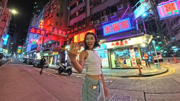 Sample image of woman standing on japanese street lit by neon shop signs at night