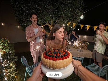 Sample photograph of woman blowing out birthday cake candles at party