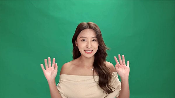 a woman saat in front of a green screen