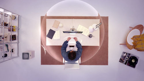 top down view of someone at a desk using the insta360 link 2 pro in a purple room