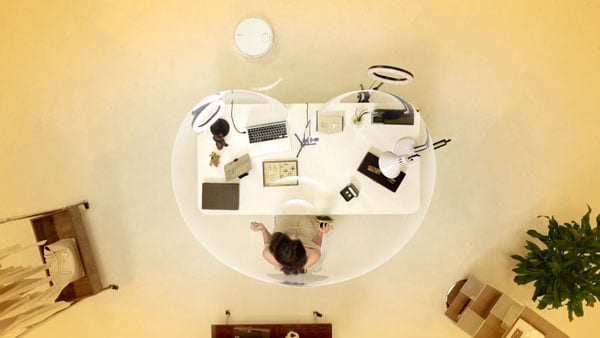 top down view of someone at a desk using the insta360 link 2 pro in a yellow room