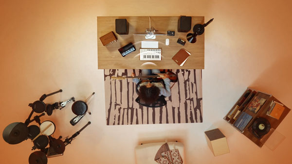 top down view of someone at a desk using the insta360 link 2 pro in a orange music studio