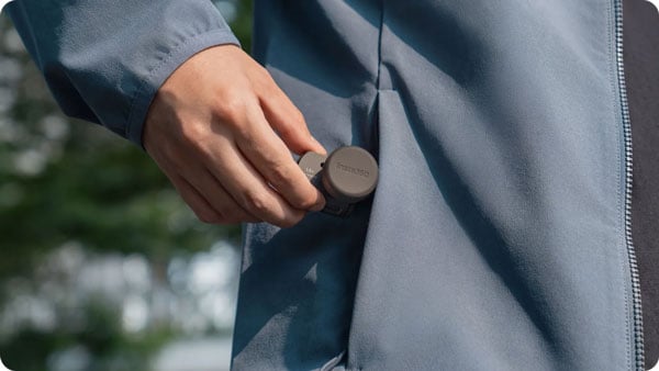 close up of someone putting the telephoto lens into their pocket