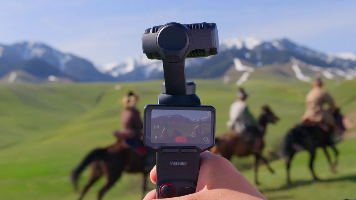 behind the camera view of three men on horses being filmed