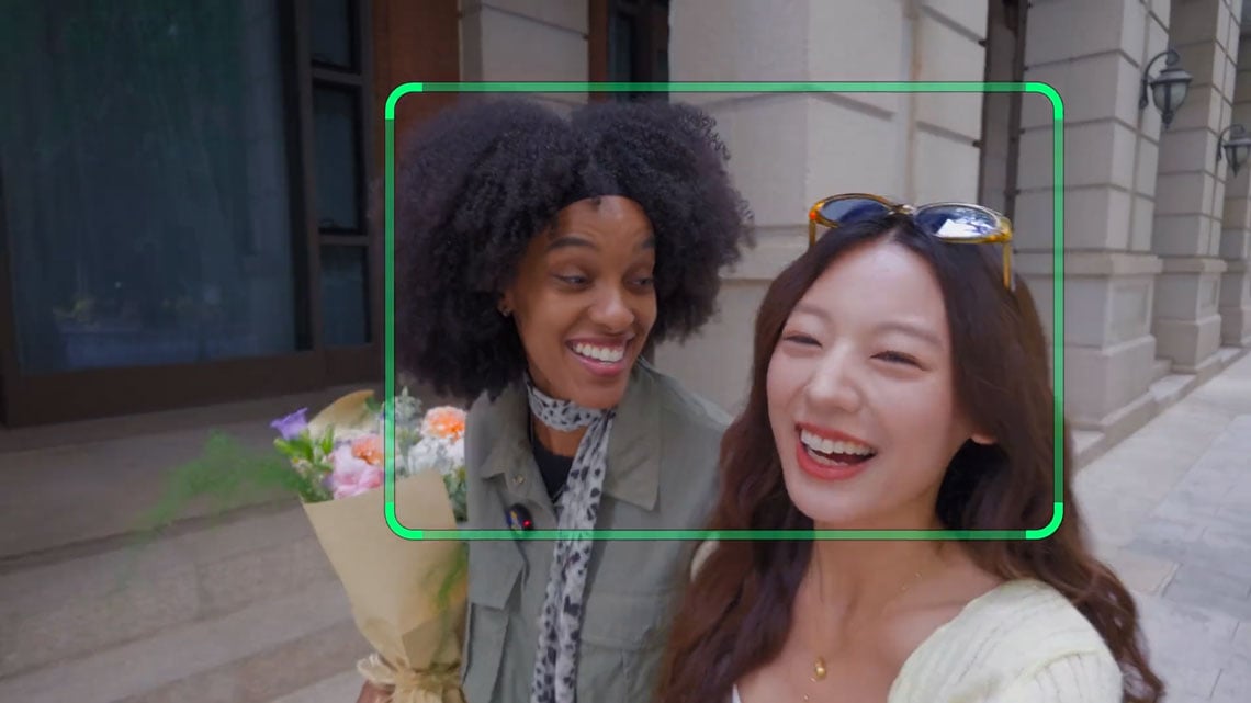 in camera tracking of two women ealking down a street talking