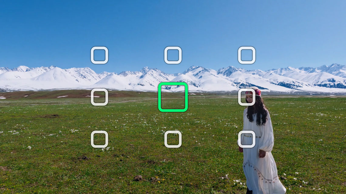 sample framing ui over the top of a woman stood in a field infront of a snowy mountain range