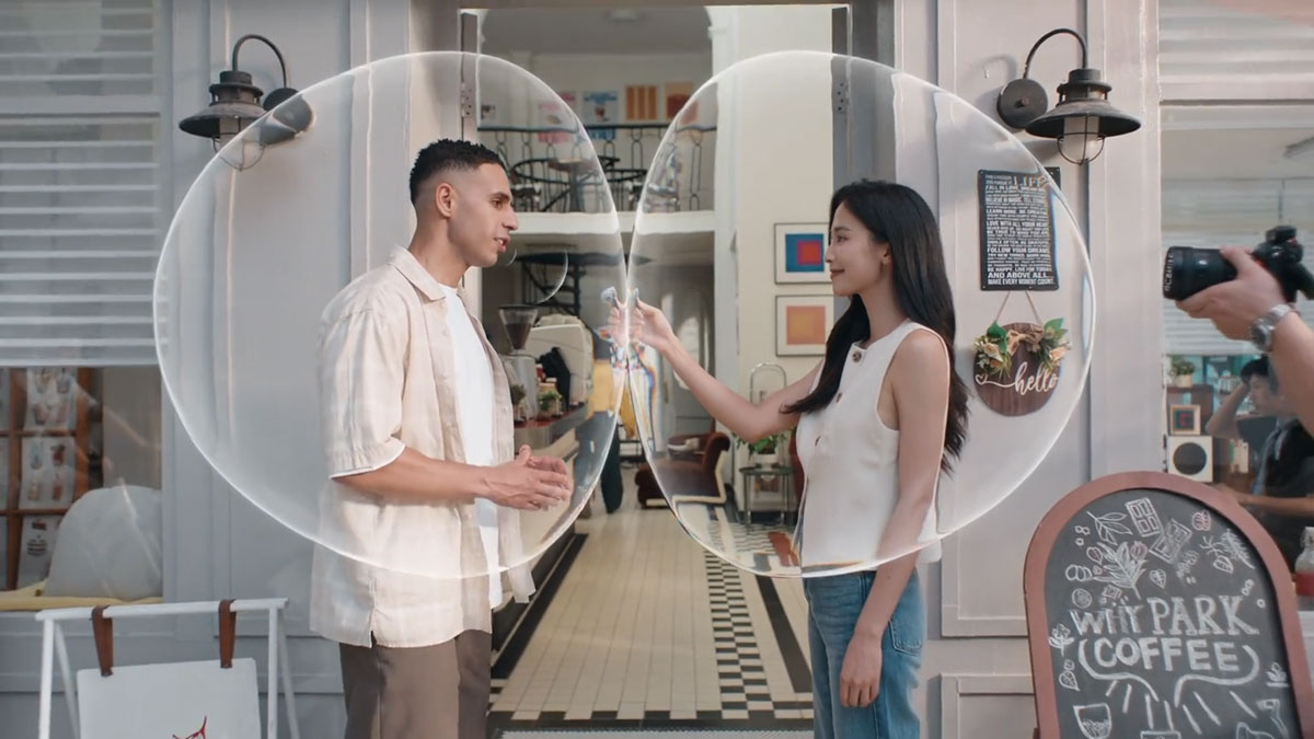 two people in bubbles being filmed outside of a cafe