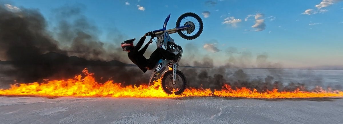 a rider performing a stunt on a dirt bike over a line of fire