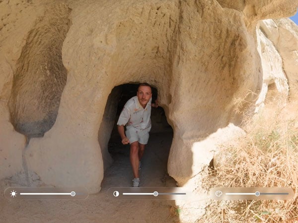 a man exploring a carved rock cave showing the insta360 x6 interface at the bottom of the image