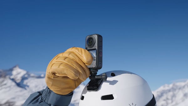 someone tapping the screen on the insta360 x6 while its attached to their helmet