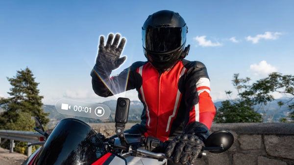 a person on a motorbike starting recording using the hand gesture