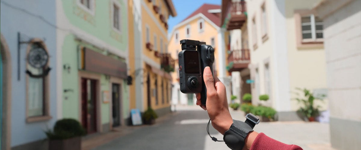 someone holding the insta360 x6 attached to the foldable selfie stick