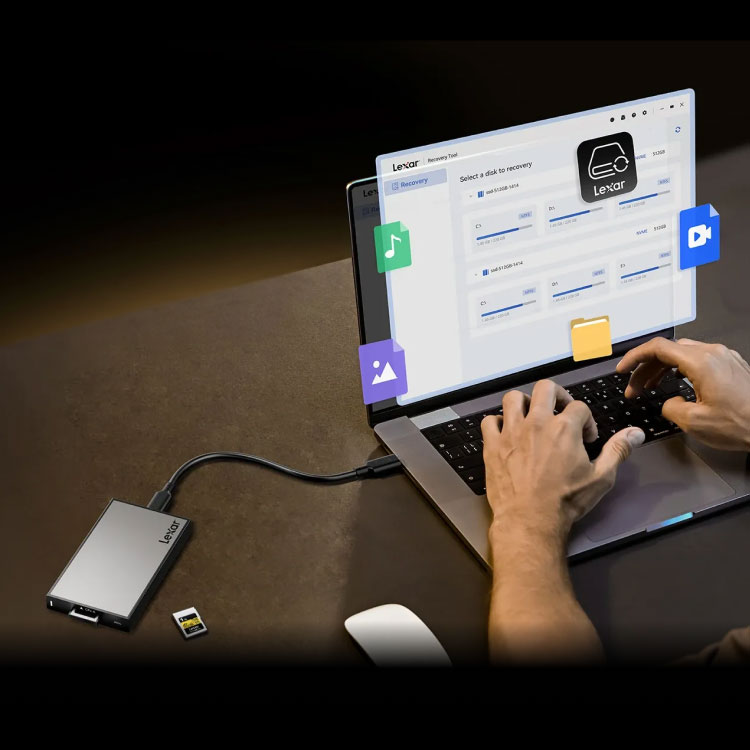 someone working on a laptop using a cfexpress card in a card reader
