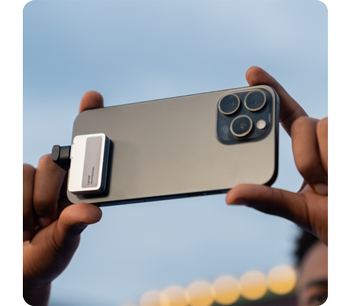 Person capturing video with iPhone 15 Max with Lexar Professional Go Portable SSD attached
