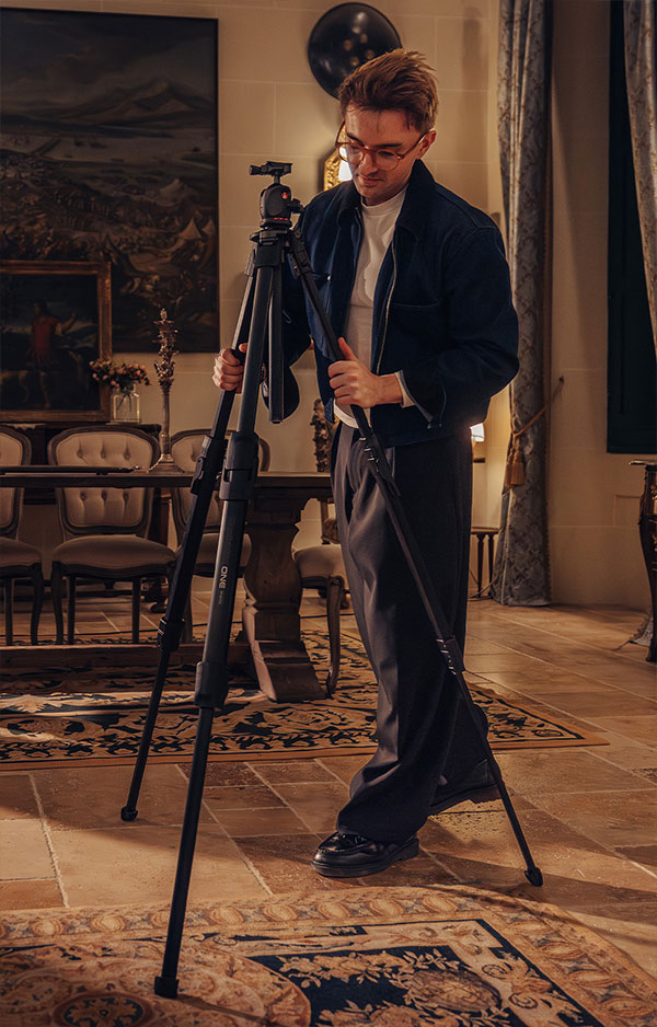 someone setting up the manfrotto tripod in a dining room