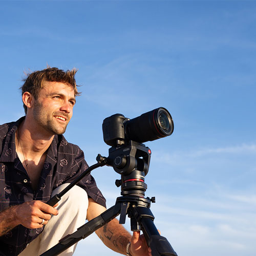 someone taking a photo using the manfrotto tripod on a low setting