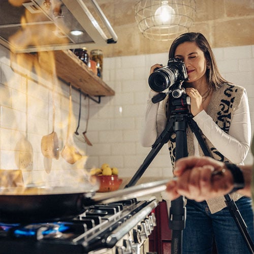 someone taking a photo of someone cooking in a pan using the manfrotto tripod