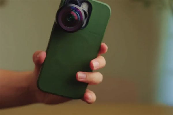 someone holding a phone with the fisheye lens attached