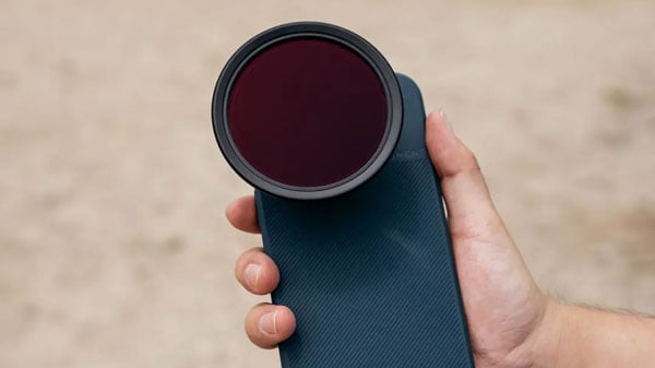 someone holding a smart phone with the moment case, lens and filter attached