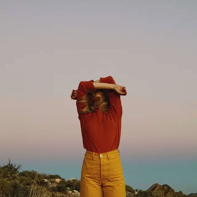 sample image of a woman streching on a cliffside