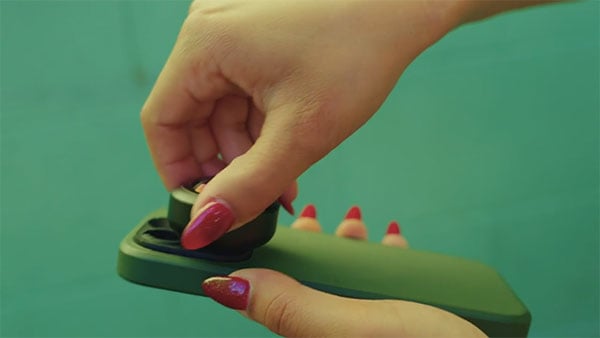 mobile lens being attached to a smartphone in a green case