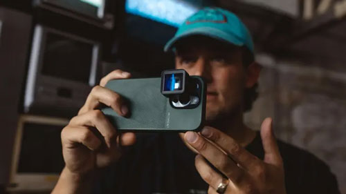 someone taking a photo on their phone using a moment case and mobile lens