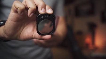 someone holding the moment antiglare filter to the camera