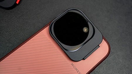 sclose up of the antiglare filter attached to a red moment phone case