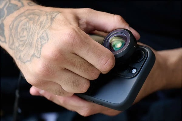 close up of someone attaching a lens to the moment phone case