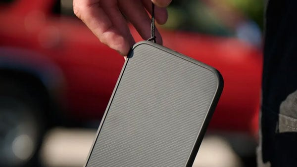 close up of someone holding the moment phone case uing a strap through the strap loop