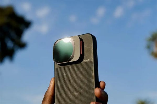 someone holding a phone with the cinebloom filter attached