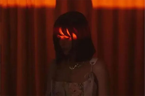 sample image of a woman in a dark red room taken with the cinebloom filter
