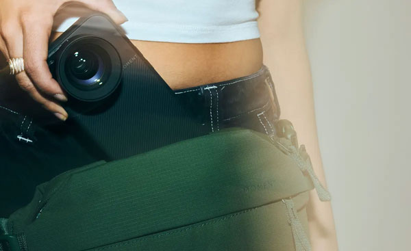 close up of someone taking their phone in a moment case with lens out of the sling bag